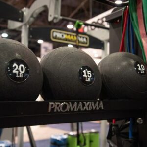 A rack of Slam Balls on display at a fitness show.